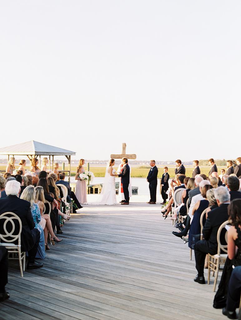 The couple intentionally chose a simple wooden cross for their altar so as not to distract from the view. To up the chic (and comfort) factor, 300-plus cushioned chairs were set out.