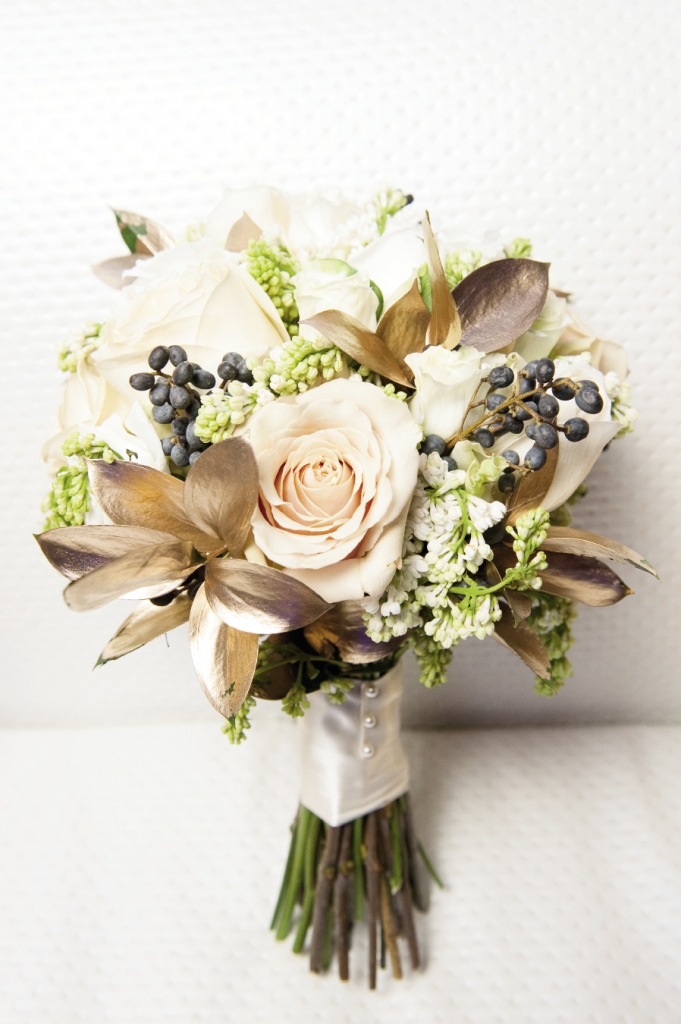 Beth LeonGuerrero of Wildflowers Inc. used blue privet berries, gilded ruscus leaves, lilacs, and roses to create a bouquet in the gold, white, and navy color scheme.