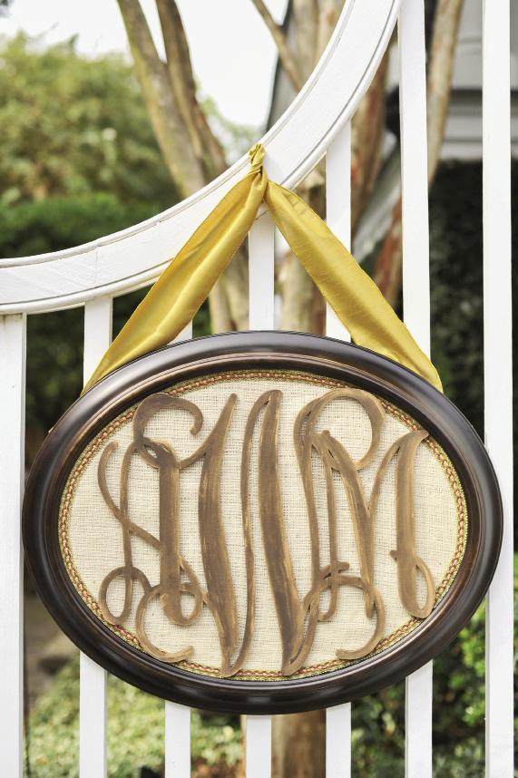 WELCOME HOME: Allison’s mother framed the couple’s monogram and hung it from the garden gates with a marigold-hued velvet ribbon to tie in the color scheme.