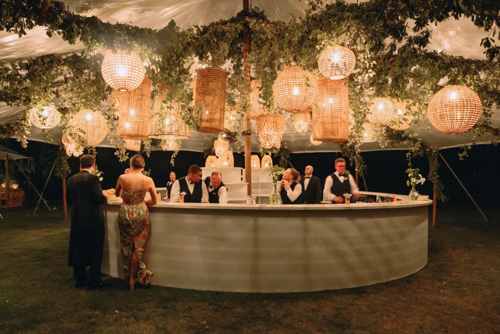 Candlelit rattan lanterns laced with greenery set the mood for the tented reception.