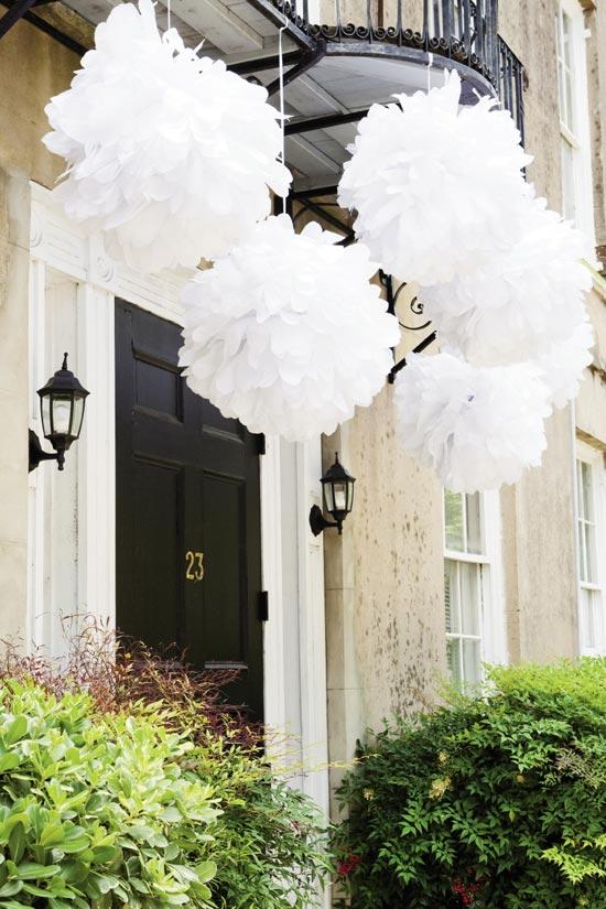 PRETTY PUFFS: Balls of bright white tissue (a summery, budget-savvy touch) popped against the venue’s stucco walls.
