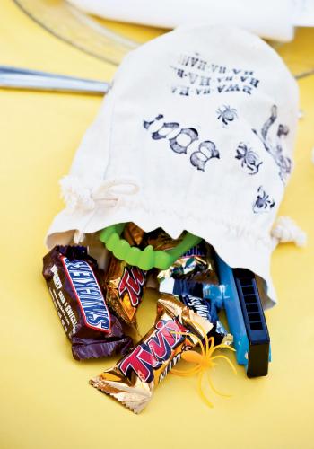 Goodie Bag: Calder stamped drawstring muslin bags with Halloween sayings and stuffed them full of candy and toys, like fake fangs and spider rings. Inexpensive treats can be found at dollar stores and discount chains. Order plain bags online and get ink stamps from craft stores.