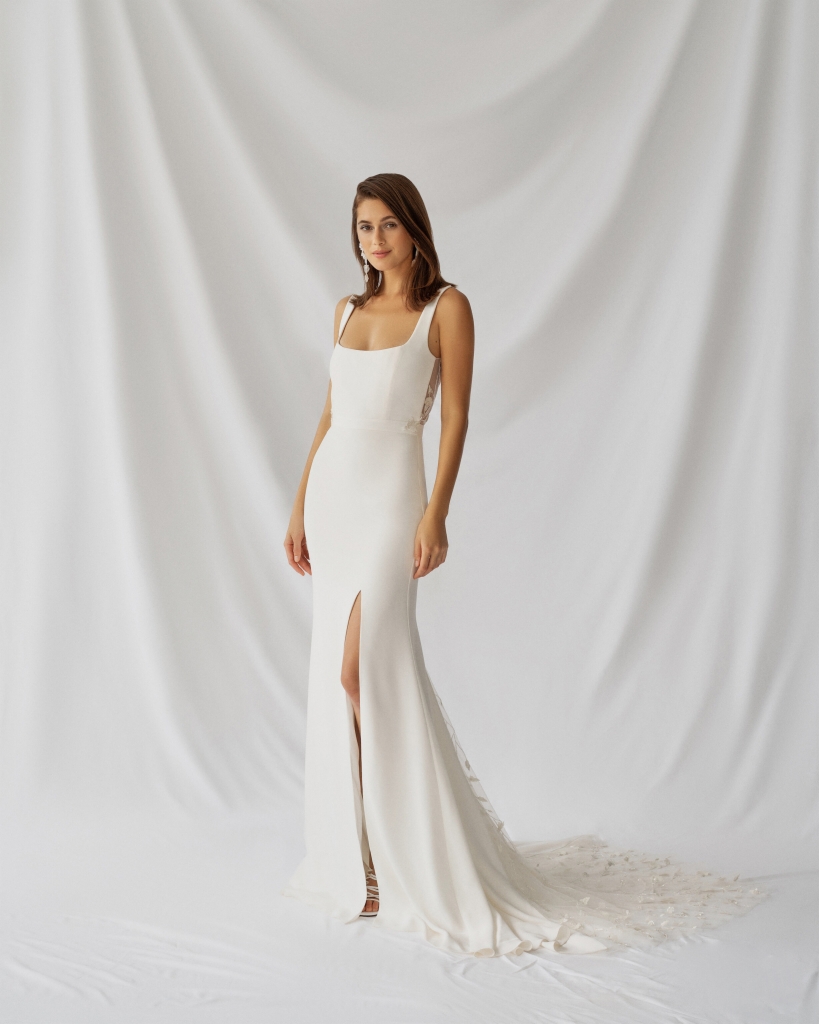DO THE SLIT - Alexandra Grecco’s “Laurel” gown, featuring a wide scoop neck, front skirt slit, and floral appliqué on the back bodice and train. Why We Love It “This is perfect for the bride who loves a classic silhouette but wants a little embellishment.”   –Nicole Brew, Lovely Brid