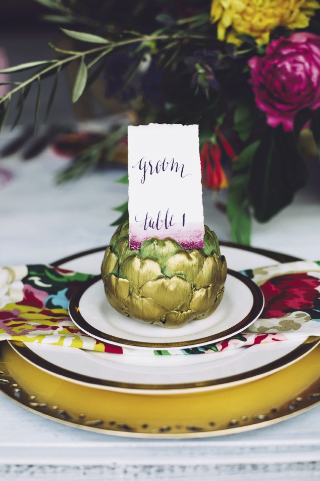 Produce makes a fanciful—and relatively inexpensive—placecard holder. Up the elegance with a wash of gold paint.  Watercolors by Britt Bates. Calligraphy by HR Deneau Paper Co. Signage by The Silver Starfish. Florals by Anna Bella Florals. Event design by Pure Luxe Bride. Image by Monika Gauthier Photography &amp; Design.