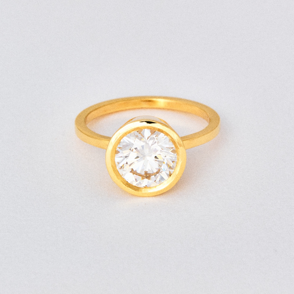 AL&amp;EM’s round bezel solitaire lab-grown diamond in a 14k-gold setting.