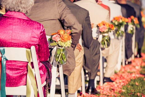 PAVE THE WAY: Pink rose petals lined the ceremony aisle and glass vessels holding coral, pink, and white florals served as lush aisle markers.