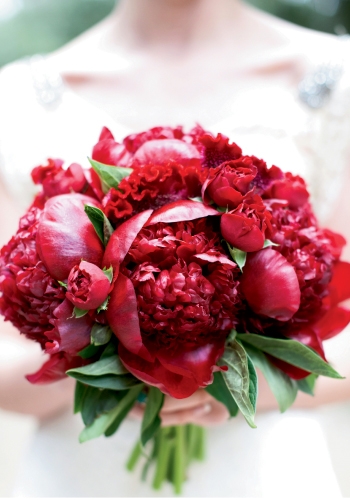 THE BOLD &amp; THE BEAUTIFUL: The intensely red peonies and roses of Ashley’s bouquet by Eventa Bella Charleston saturated her walk down the aisle with color.