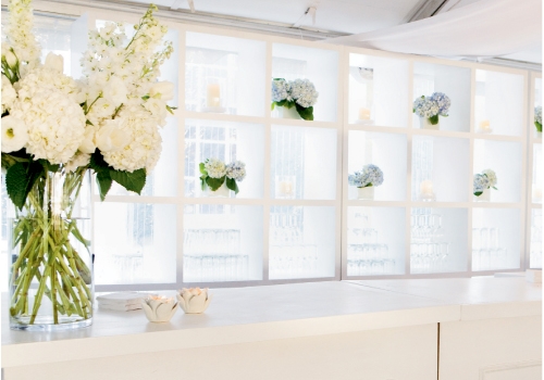 SOMETHING BLUE: Heather Barrie of gathering—floral + event design tucked low vases of pale blue hydrangeas in a shelf in the bar area for a soft, secondary accent color.